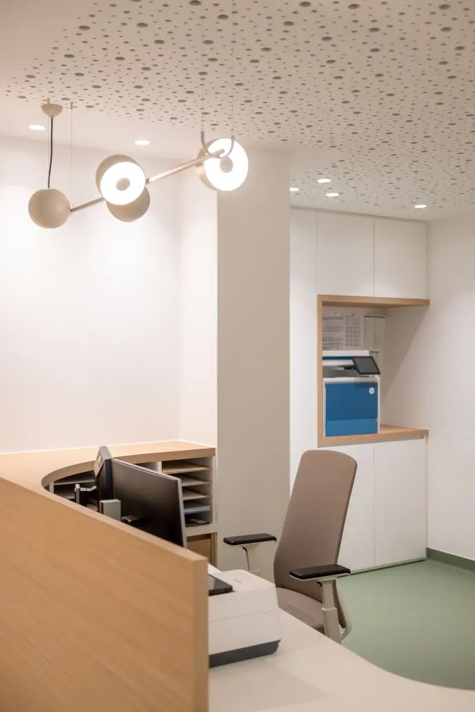 Ergonomische onthaalwerkplek met maatwerkbalie en bureaustoel in de vernieuwde longartsenpraktijk in Sint-Truiden.