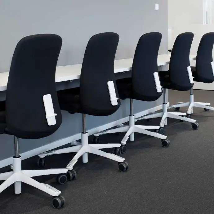 Zwarte HÅG SoFi 7300 stoelen met volledig gestoffeerde rugleuning voor kantoor en gedeelde werkplekken Rij zwarte HÅG SoFi 7300 bureaustoelen aan werkplekken