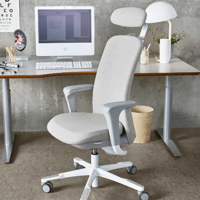 HÅG SoFi 7300 met volledig gestoffeerde rugleuning, hoofdsteun en lichte afwerking voor een ergonomische thuiswerkplek HÅG SoFi 7300 bureaustoel met hoofdsteun aan een thuiswerkbureau